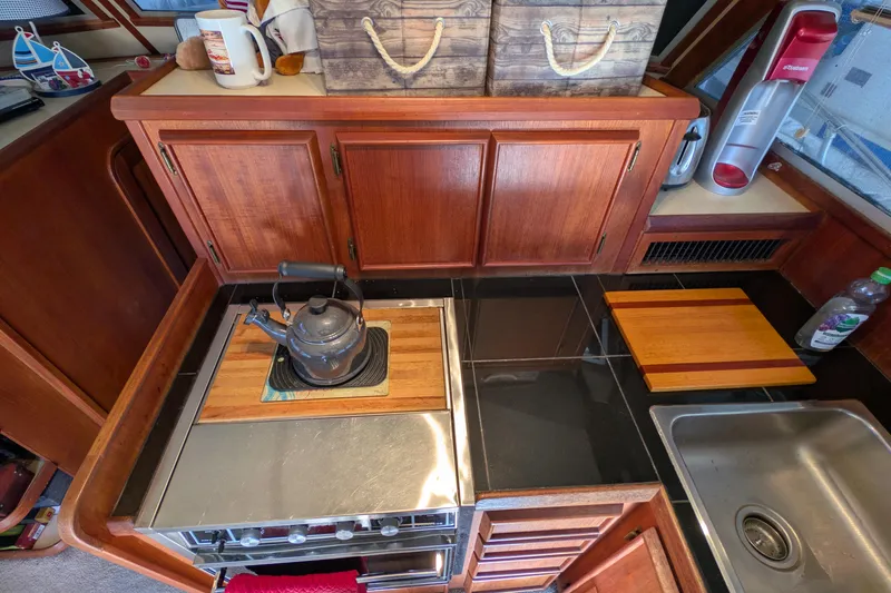 Slide: The Image of 1984 Chris-Craft 382 Commander kitchen with stove, sink, and wooden cabinets. - 43