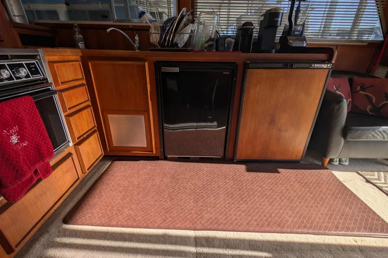 Slide: The Image of 1984 Chris-Craft 382 Commander interior kitchen with wooden cabinets and appliances. - 46