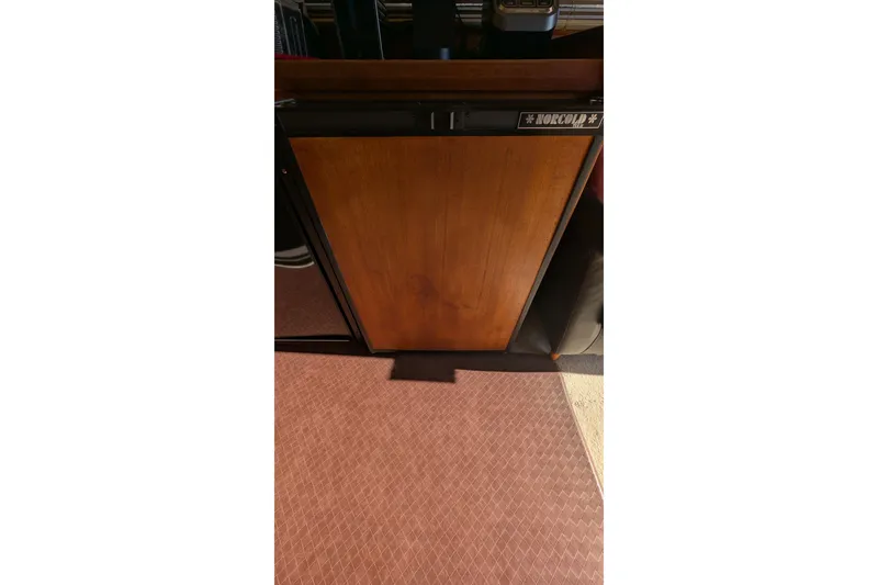 Slide: The Image of Wooden panel on a Norcold fridge inside a 1984 Chris-Craft 382 Commander boat. - 47