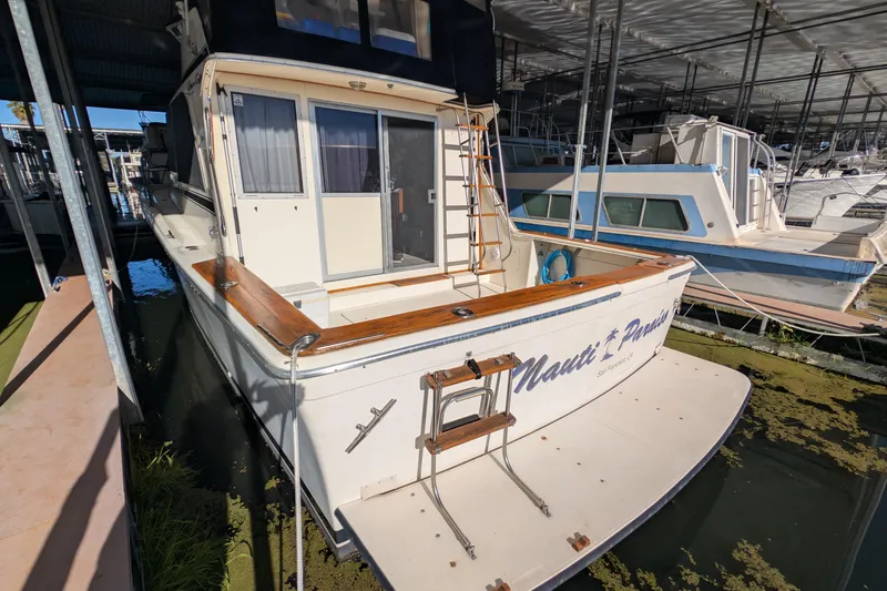 Slide: The Image of 1984 Chris-Craft 382 Commander docked in a marina, rear view with wooden accents. - 5