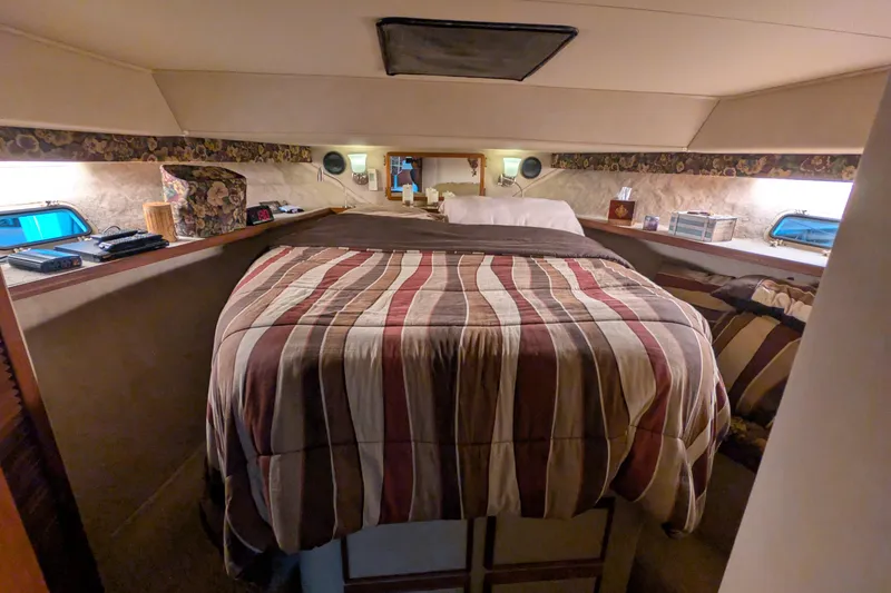 Slide: The Image of 1984 Chris-Craft 382 Commander cabin with striped bedding and cozy interior decor. - 67