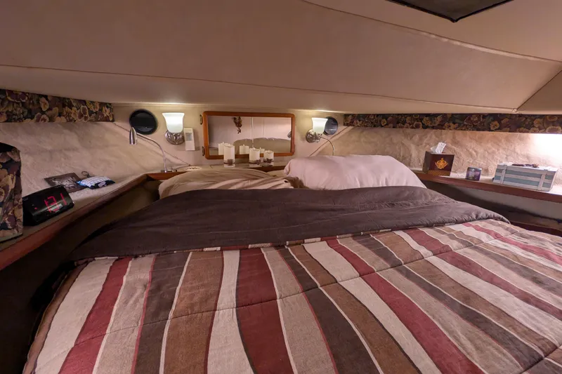 Slide: The Image of Cozy cabin interior of 1984 Chris-Craft 382 Commander with striped bedding and ambient lighting. - 68