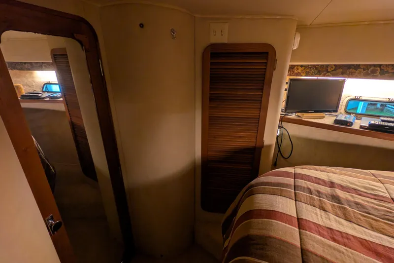 Slide: The Image of 1984 Chris-Craft 382 Commander cabin interior with bed, TV, and wooden accents. - 69