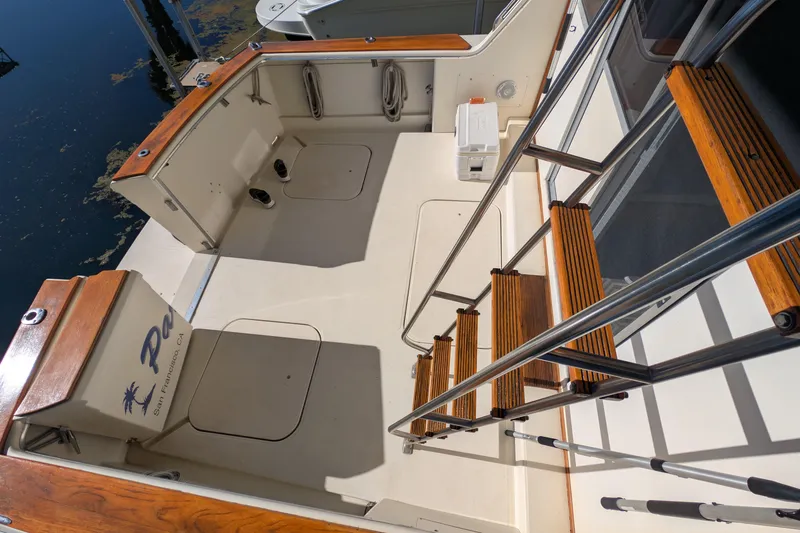 Slide: The Image of 1984 Chris-Craft 382 Commander boat deck with wooden stairs and seating area. - 7