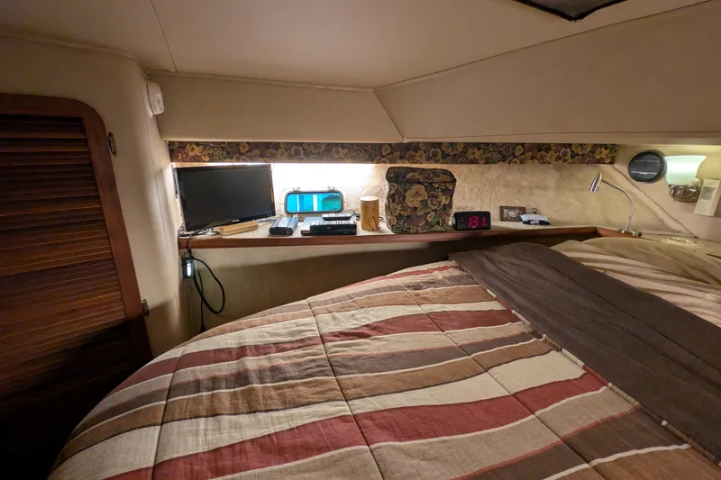 Slide: The Image of Cozy cabin interior of 1984 Chris-Craft 382 Commander with striped bedding and electronics. - 70