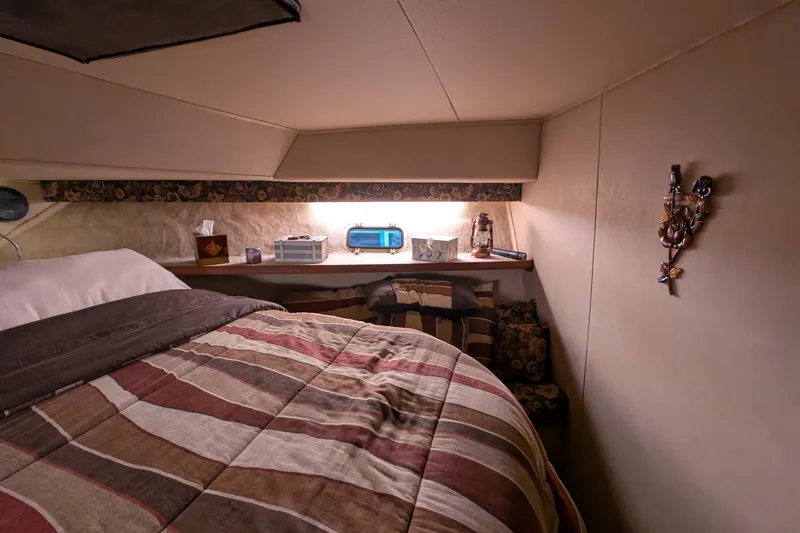 Slide: The Image of Cozy cabin interior of 1984 Chris-Craft 382 Commander with striped bedding and decorative accents. - 72