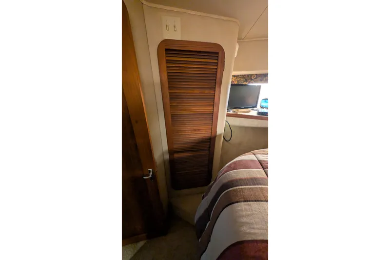 Slide: The Image of 1984 Chris-Craft 382 Commander interior with wooden louvered door and cozy bedding. - 73
