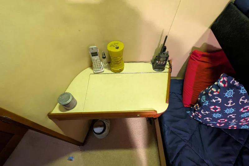 Slide: The Image of 1984 Chris-Craft 382 Commander cabin interior with table, phone, radio, and nautical-themed pillows. - 77