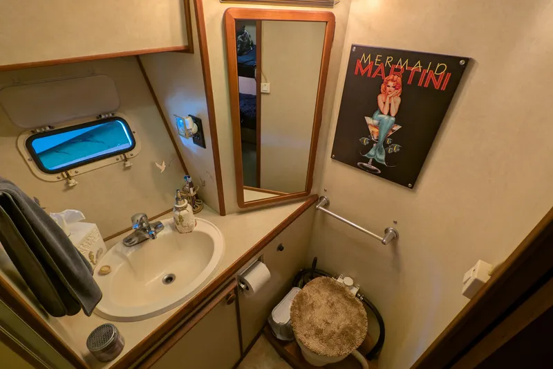 Slide: The Image of 1984 Chris-Craft 382 Commander bathroom with sink, mirror, and "Mermaid Martini" poster. - 79