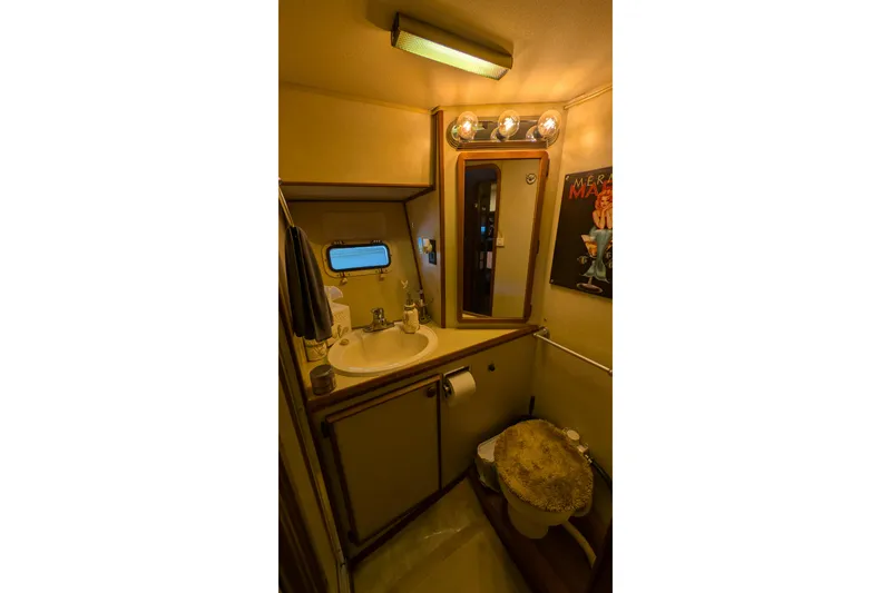 Slide: The Image of 1984 Chris-Craft 382 Commander bathroom with sink, mirror, and toilet. - 82