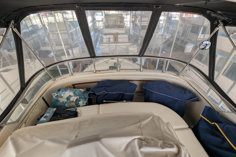 Slide: The Image of 1984 Chris-Craft 382 Commander interior with covered seating and marina view. - 9