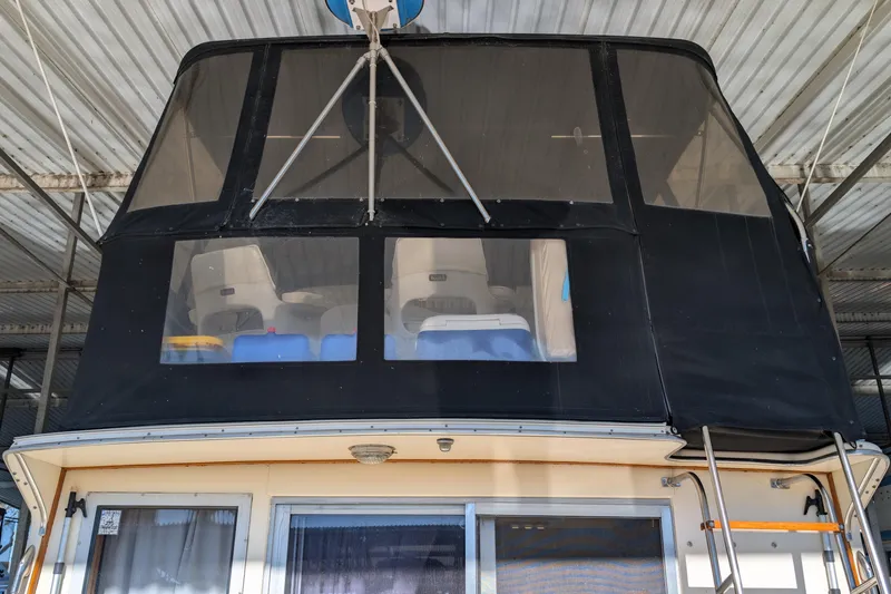 Slide: The Image of 1984 Chris-Craft 382 Commander boat with covered upper deck in a marina. - 96