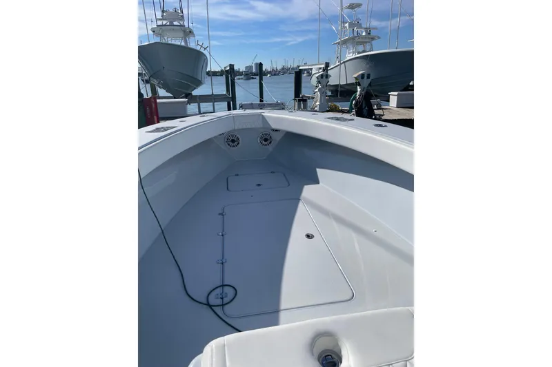 Slide: The Image of 2022 Conch 33 boat interior at dock, showcasing spacious deck and sleek design. - 12
