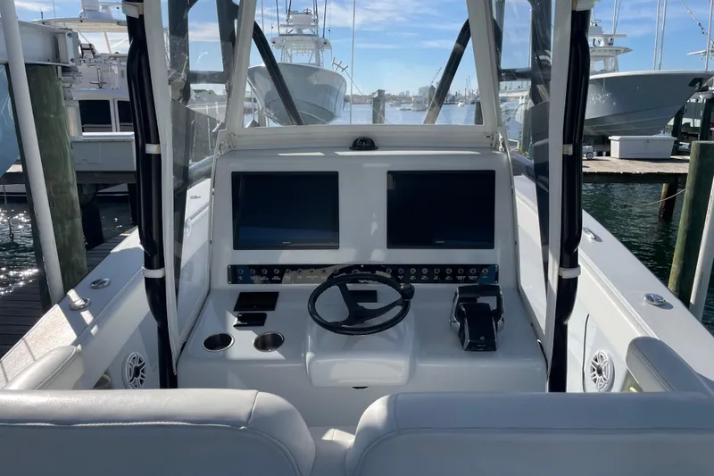 Slide: The Image of 2022 Conch 33 boat cockpit with dual screens and steering wheel at marina. - 7