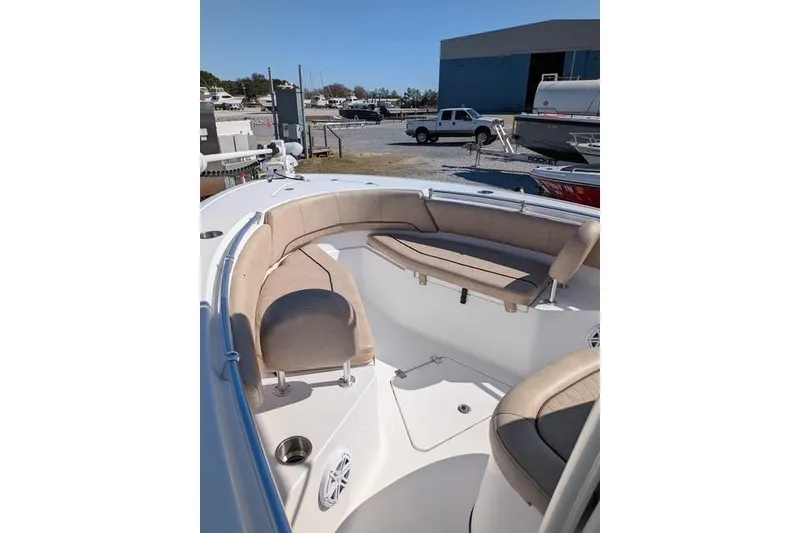 Slide: The Image of 2020 Sportsman Open 232 Center Console boat with beige seating in a marina setting. - 5