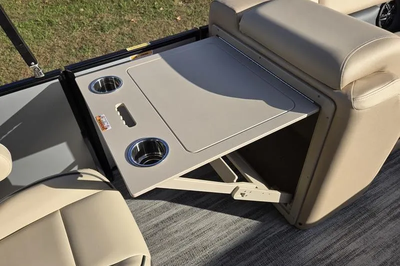 Slide: The Image of 2025 Godfrey Sweetwater 2286 QS boat interior with foldable table and cup holders. - 2