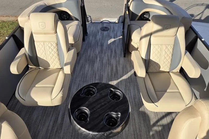 Slide: The Image of 2025 Godfrey Sweetwater 2286 QS boat interior with beige seating and round table. - 5