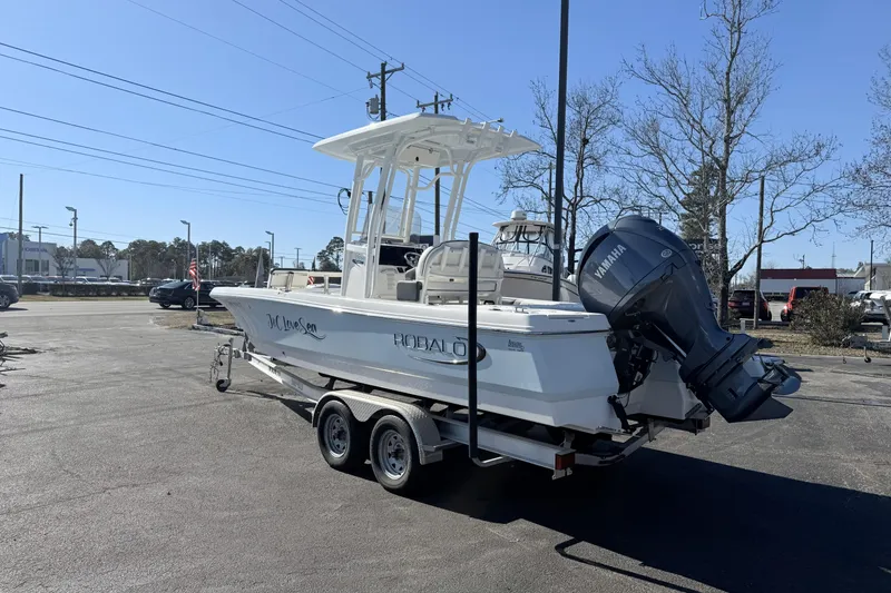Slide: The Image of 2023 Robalo 226 Cayman boat on trailer with Yamaha outboard motor in parking lot. - 1
