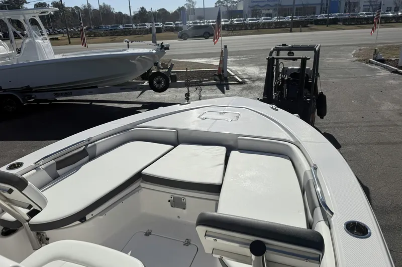 Slide: The Image of 2023 Robalo 226 Cayman boat interior with seating, parked near a road. - 3