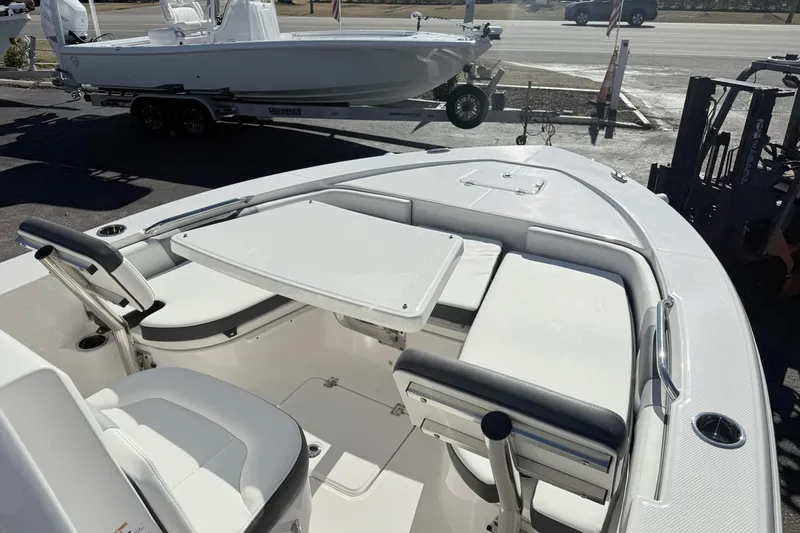 Slide: The Image of 2023 Robalo 226 Cayman boat interior with seating and table, parked on a trailer. - 5