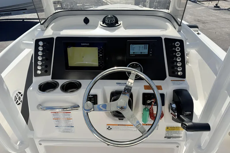 Slide: The Image of 2023 Robalo 226 Cayman boat dashboard with steering wheel and navigation controls. - 6