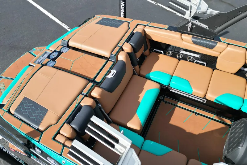 Slide: The Image of 2023 Malibu M220 boat interior with tan and teal seating, cup holders, and sleek design. - 12