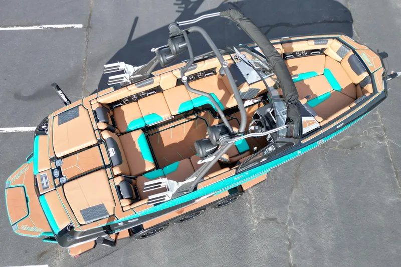 Slide: The Image of 2023 Malibu M220 boat with tan and teal interior, aerial view. - 16