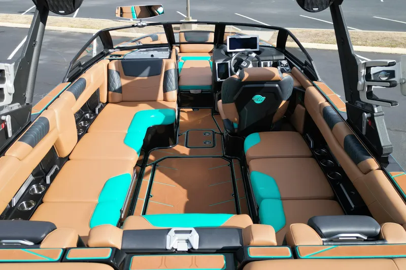 Slide: The Image of 2023 Malibu M220 boat interior with tan and teal seating, modern dashboard, and spacious layout. - 8