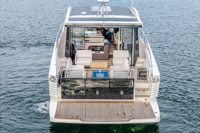 Slide: The Image of 2026 Absolute 48 Coupe yacht on water, showcasing spacious deck and modern design. - 1