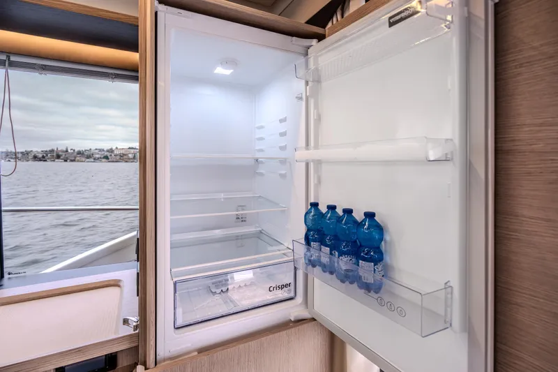 Slide: The Image of Open fridge with water bottles inside, aboard 2026 Absolute 48 Coupe yacht. - 36