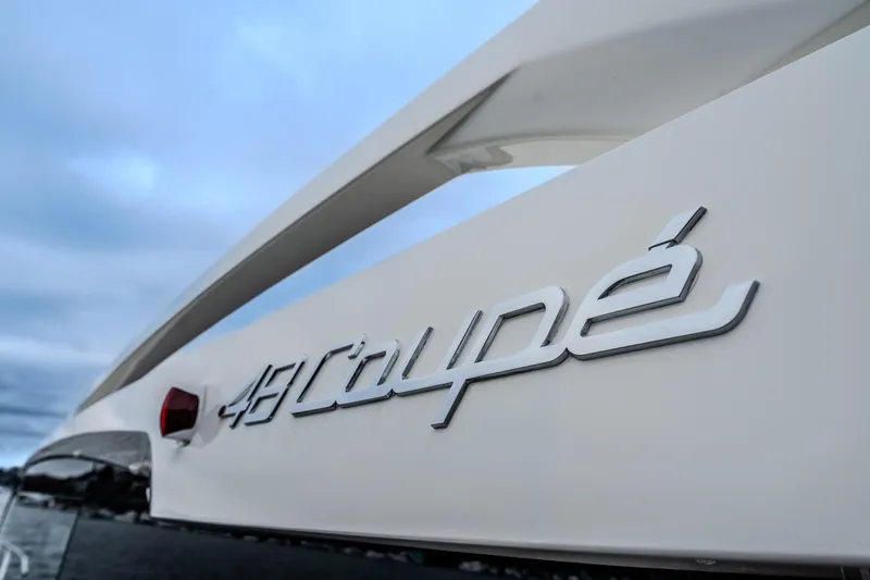 Slide: The Image of 2026 Absolute 48 Coupe yacht logo against a cloudy sky backdrop. - 7