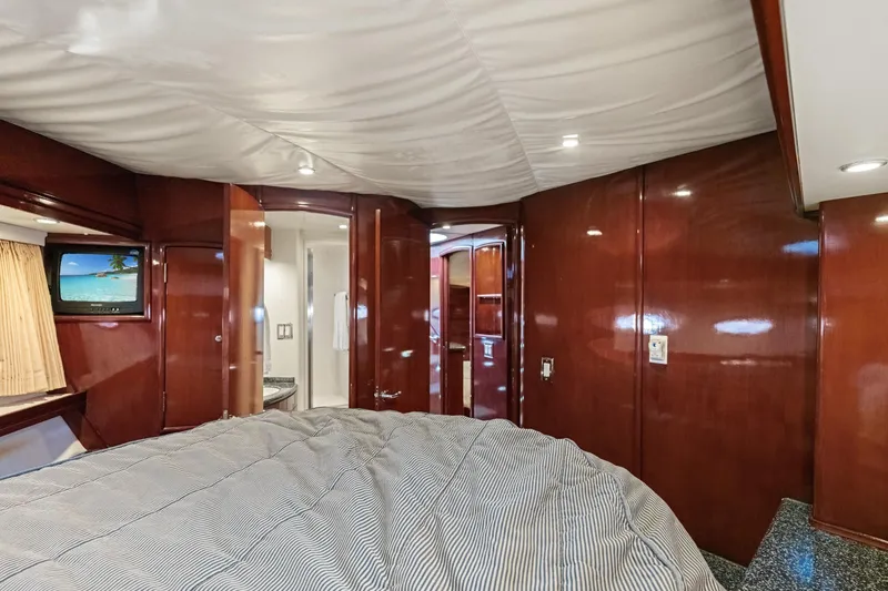Slide: The Image of Luxurious interior of 1999 Carver 53 Voyager yacht with wood paneling and cozy bedding. - 26