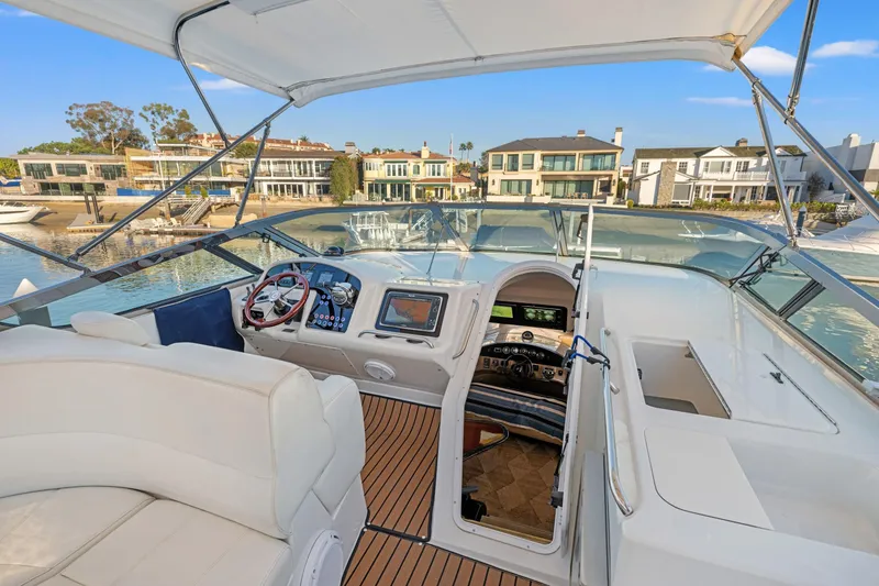 Slide: The Image of 1999 Carver 53 Voyager yacht helm with luxurious seating and waterfront view. - 30