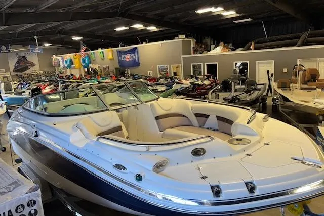 Slide: The Image of 2015 Hurricane SunDeck 2200 OB boat displayed in a showroom with various watercraft. - 29