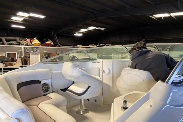 Slide: The Image of 2015 Hurricane SunDeck 2200 OB boat interior with white seating in a garage setting. - 34