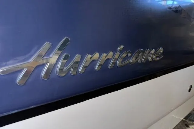 Slide: The Image of 2015 Hurricane SunDeck 2200 OB boat logo on blue and white hull. - 5