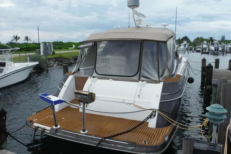 Slide: The Image of 1999 Cruisers 4270 Express yacht docked at marina, featuring sleek design and spacious deck. - 2