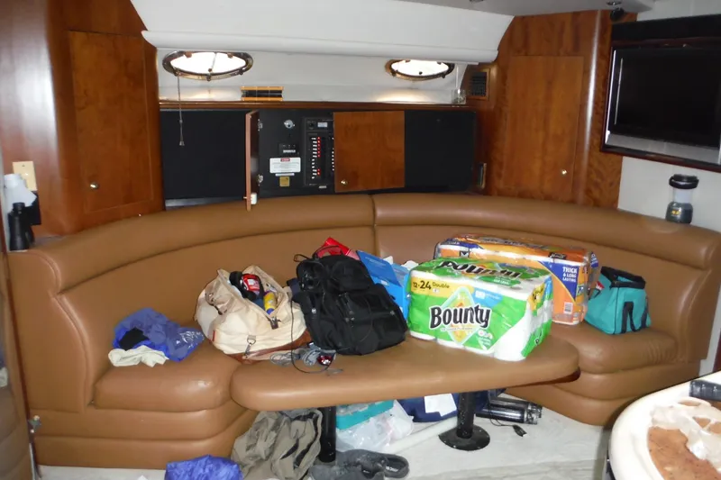 Slide: The Image of 1999 Cruisers 4270 Express yacht interior with brown seating and various supplies. - 22