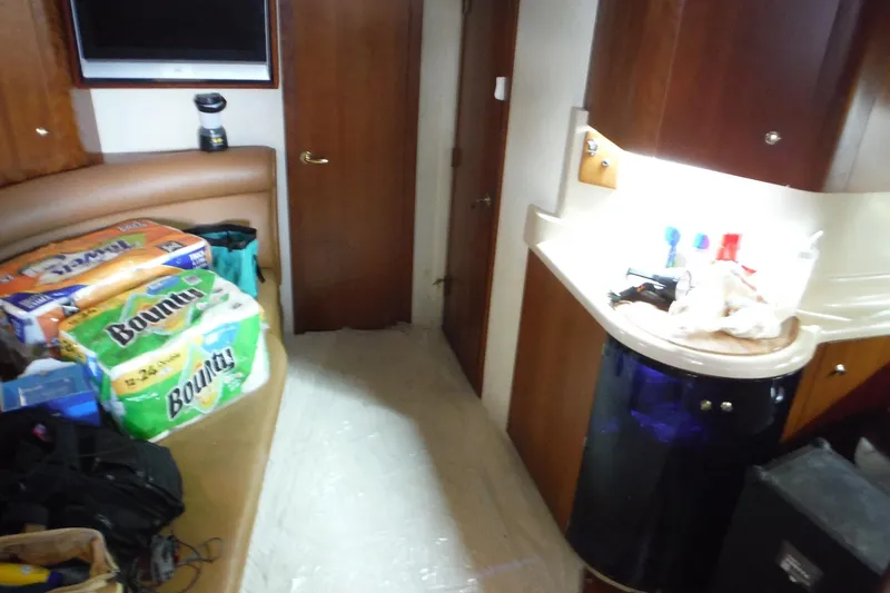 Slide: The Image of 1999 Cruisers 4270 Express cabin interior with supplies and kitchenette area. - 28