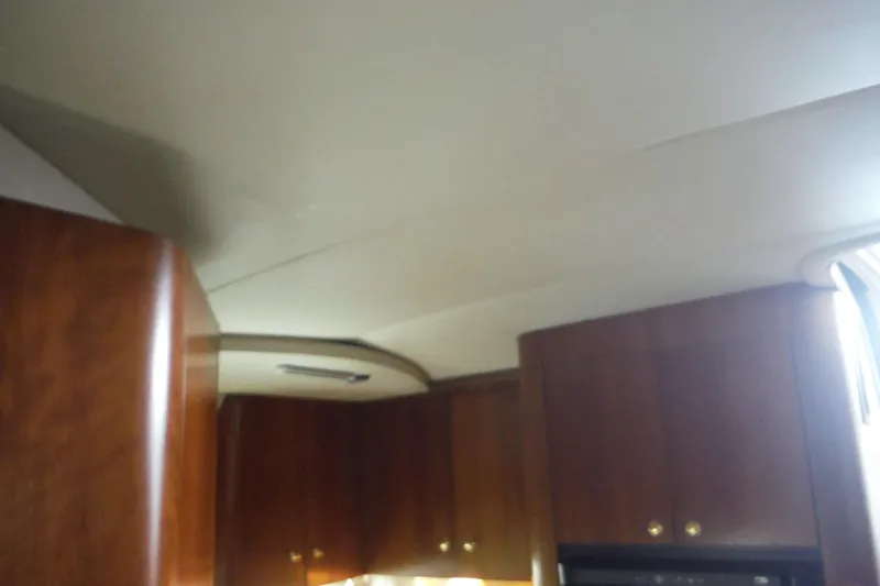 Slide: The Image of Interior view of 1999 Cruisers 4270 Express with wooden cabinets and ceiling detail. - 37