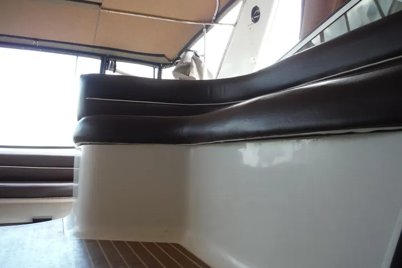 Slide: The Image of 1999 Cruisers 4270 Express interior seating with brown cushions and wooden flooring. - 41