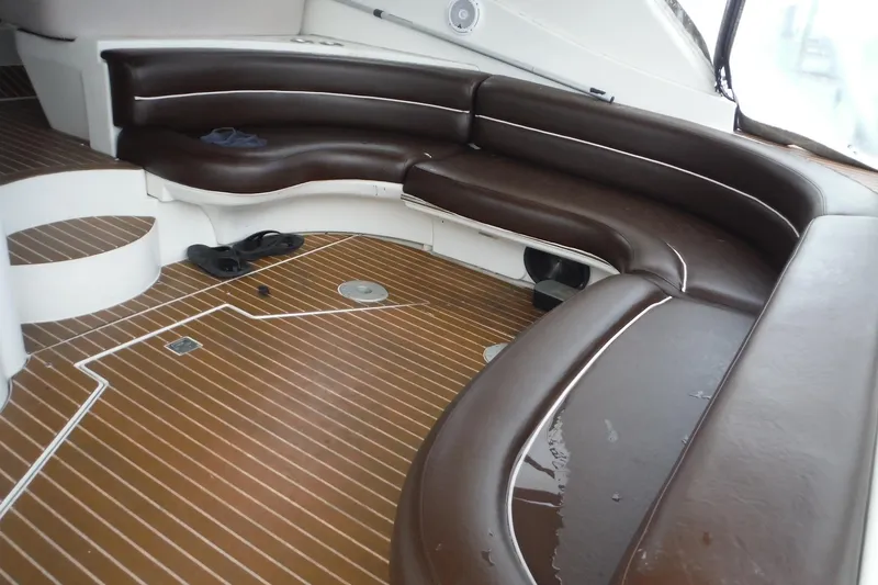 Slide: The Image of 1999 Cruisers 4270 Express boat interior with brown leather seating and wooden flooring. - 6