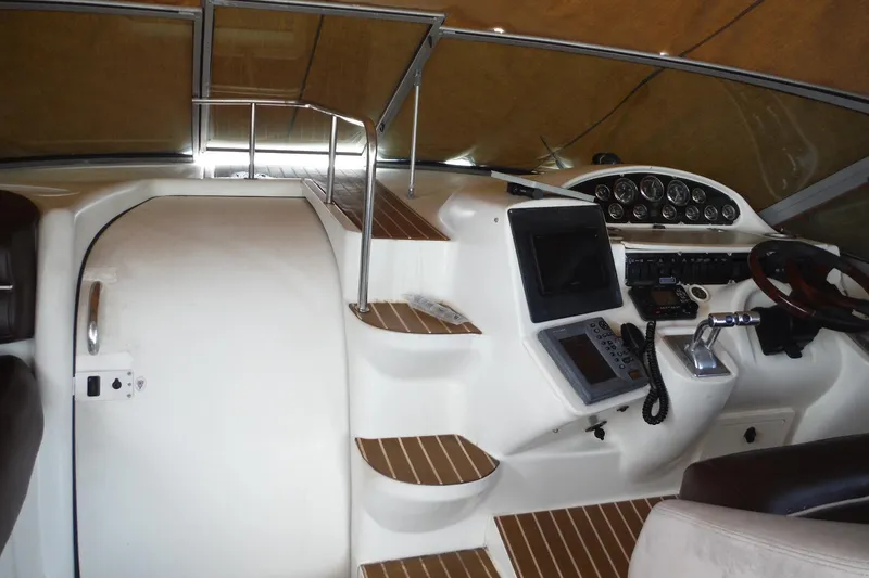 Slide: The Image of 1999 Cruisers 4270 Express helm with navigation instruments and wooden accents. - 11