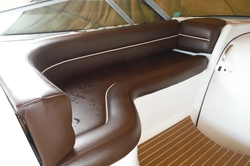 Slide: The Image of 1999 Cruisers 4270 Express boat interior with brown leather seating and wood flooring. - 44