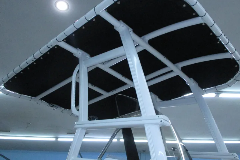 Slide: The Image of 2022 Trophy boat T-top with black canvas and white frame, indoor lighting. - 13