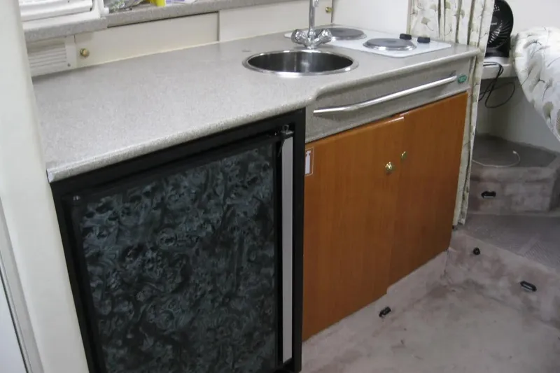 Slide: The Image of Compact kitchen area in a 2000 Formula 31 Performance Cruiser with sink and stove. - 27