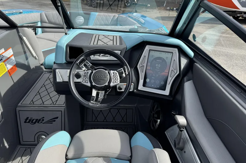 Slide: The Image of 2018 Tigé RZX3 boat interior with steering wheel and touchscreen display. - 10