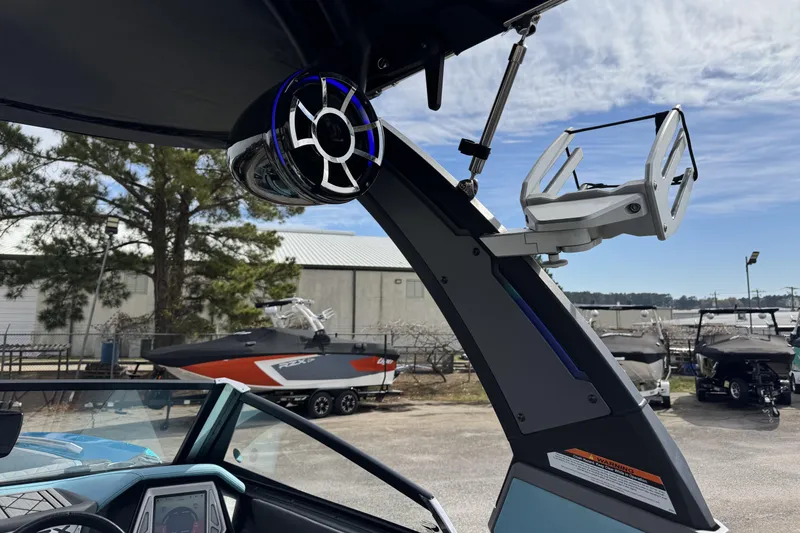 Slide: The Image of 2018 Tigé RZX3 boat with speaker and wakeboard rack, parked outdoors. - 14