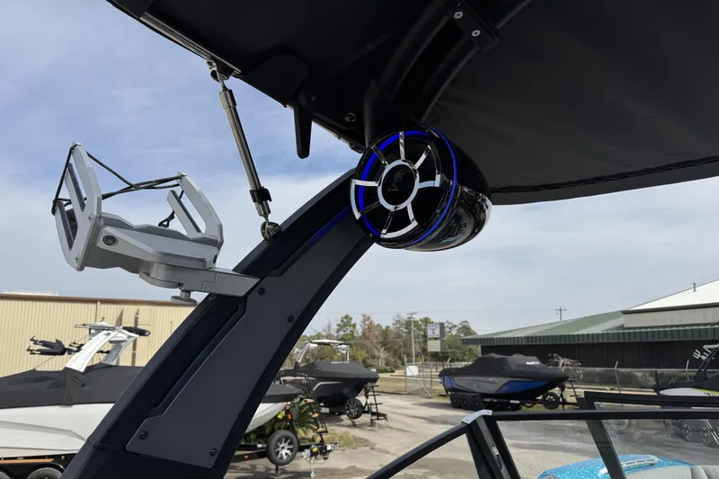 Slide: The Image of 2018 Tigé RZX3 boat with mounted speaker and wakeboard rack in a marina setting. - 15