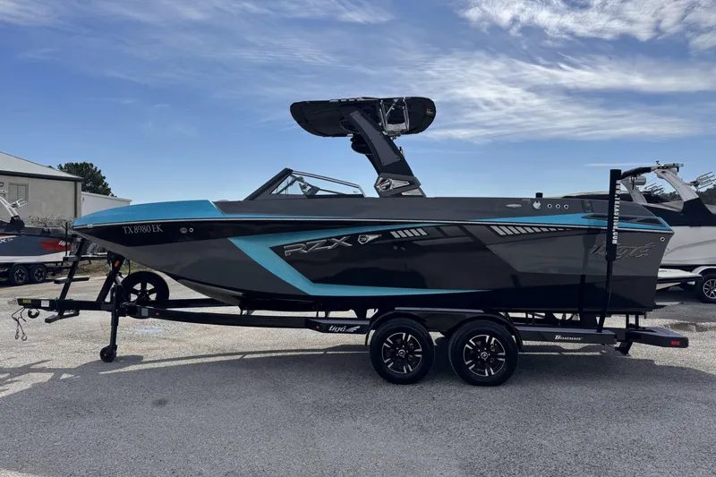 Slide: The Image of 2018 Tigé RZX3 boat on trailer, sleek design with blue and black accents. - 5